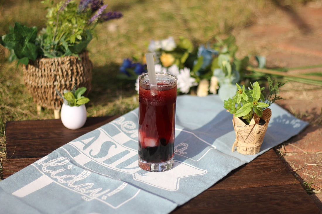 Meisterwerke der Erfrischung: Selbstgemachter Eistee mit losen Tee in einem Glas auf einer hübschen Unterlage.